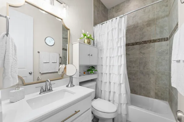 a bedroom with a bed table and a flat screen tv