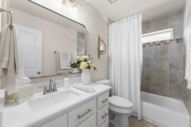 a bedroom with a bed a couch and a potted plant