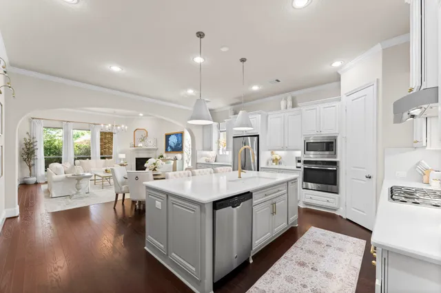 a large white kitchen with a large window and stainless steel appliances