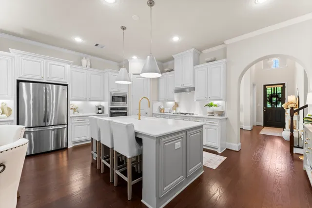 a kitchen with stainless steel appliances granite countertop a lot of counter space and wooden floors