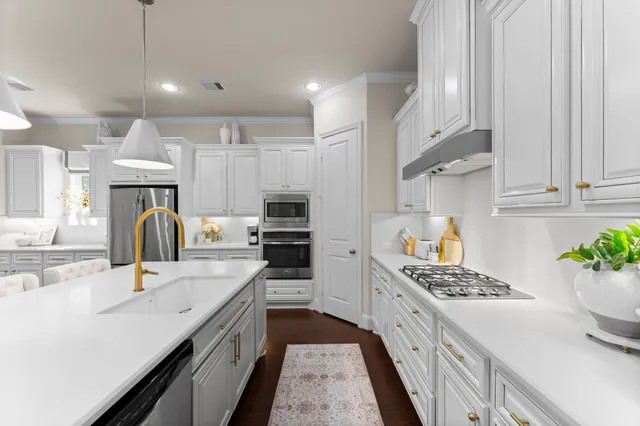 a kitchen with kitchen island granite countertop a sink appliances cabinets and a counter top space