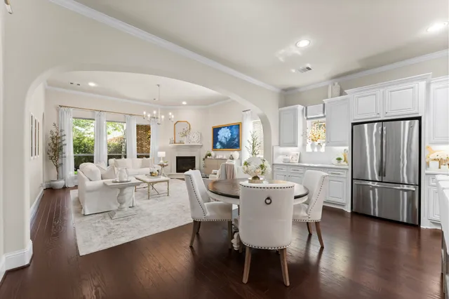 a view of a dining room with furniture a refrigerator and wooden floor