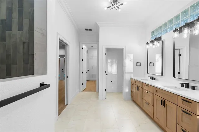 a large white bathroom with a double vanity sink a large mirror and a shower