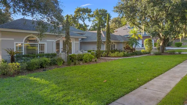 a front view of a house with a yard and trees