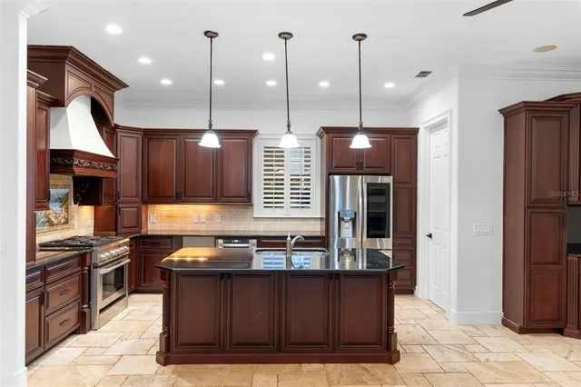 a kitchen with stainless steel appliances granite countertop a stove a sink and a refrigerator