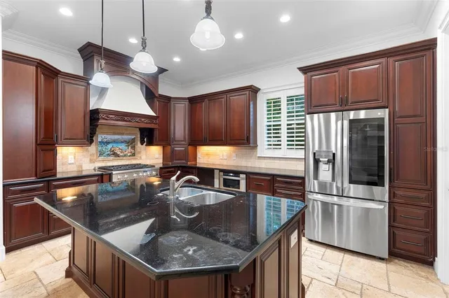 a kitchen with stainless steel appliances granite countertop a sink refrigerator and cabinets
