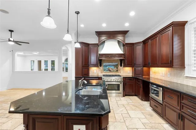 a kitchen with stainless steel appliances granite countertop a stove a refrigerator a sink dishwasher and cabinets with wooden floor