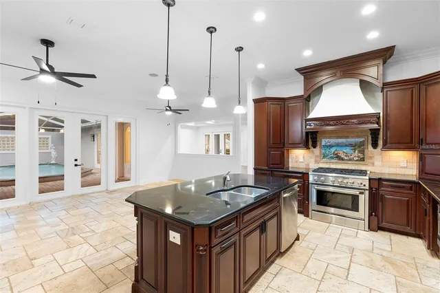 a kitchen with stainless steel appliances granite countertop a stove a sink a refrigerator and a oven