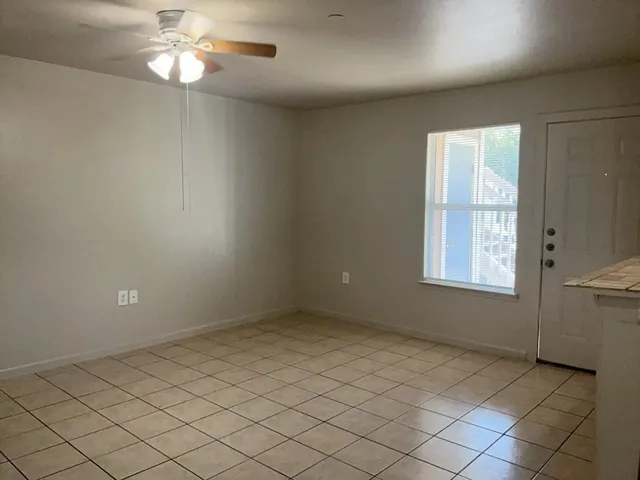 an empty room with chandelier fan