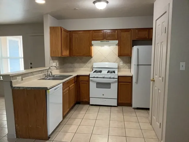 a kitchen with a stove top oven and cabinets