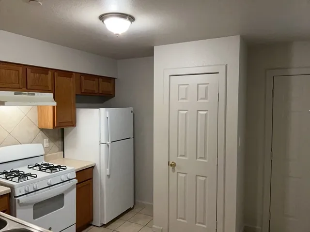 a white refrigerator freezer and a stove sitting inside of a kitchen