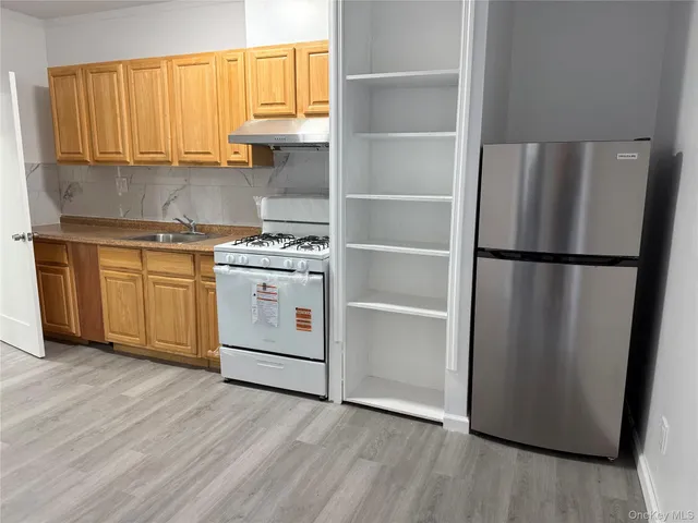 a kitchen with a refrigerator stove and wooden cabinets