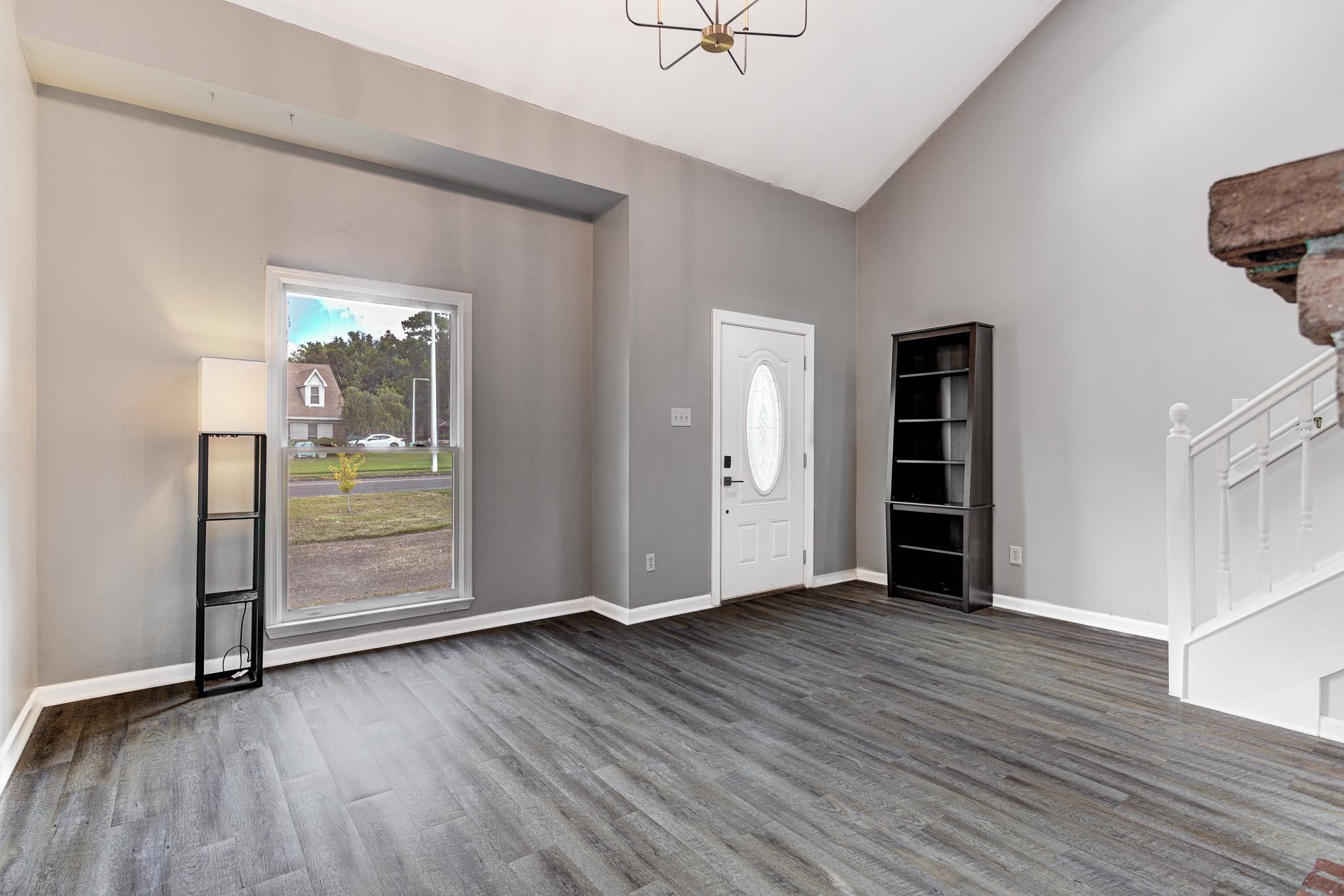 218 South Walnut Bend Road Memphis, TN 38018 - Photo 4 of 25 Entryway with stairs, dark wood-style flooring, a chandelier, and high vaulted ceiling
