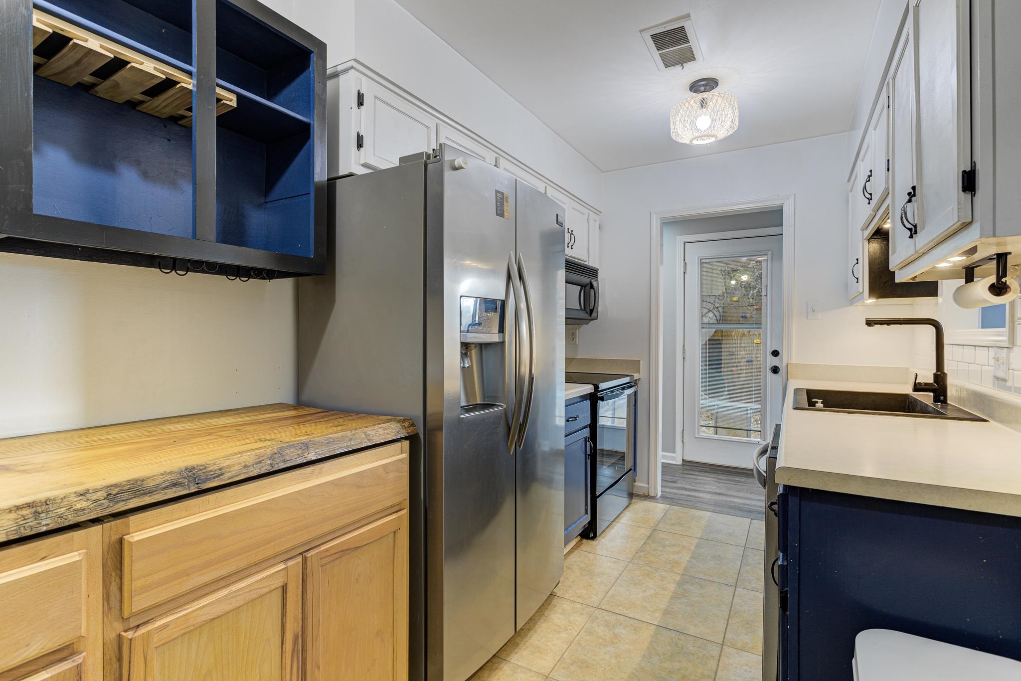 218 South Walnut Bend Road Memphis, TN 38018 - Photo 8 of 25 Kitchen featuring black appliances, light tile patterned flooring, and white cabinetry