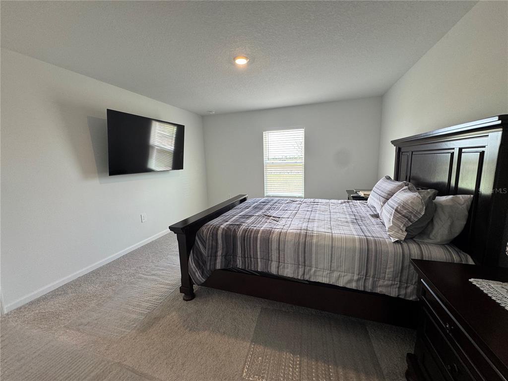 2405 Bluestone Road Haines City, FL 33844 - Photo 10 of 18 a bedroom with a bed and a flat screen tv