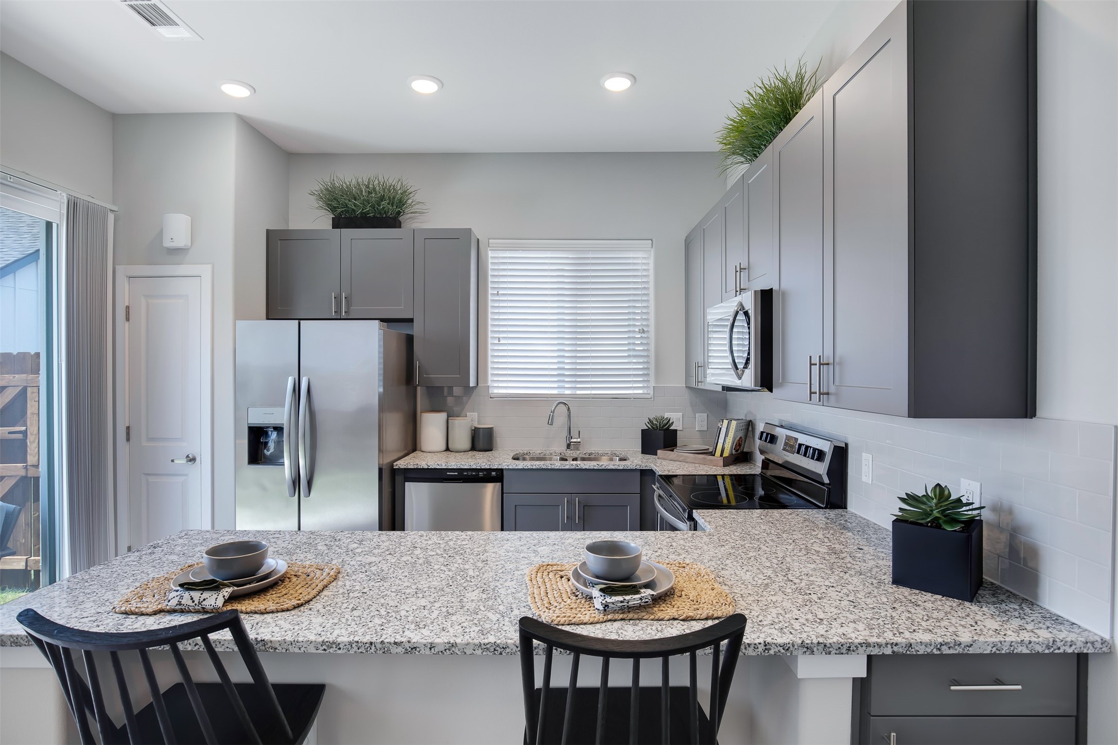 7225 Rustle Road Fort Worth, TX 76123 - Photo 11 of 38 a kitchen with stainless steel appliances granite countertop a stove a sink a refrigerator and a refrigerator with wooden floor