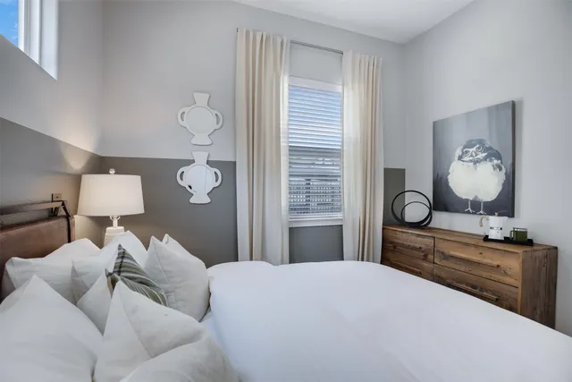 a bedroom with a bed and window with chair