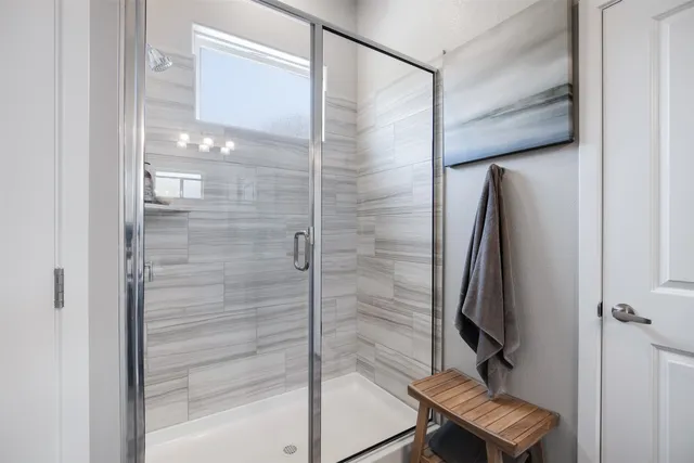 a bathroom with a shower and a glass door