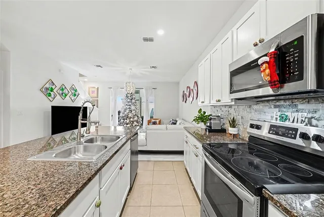 a kitchen with stainless steel appliances granite countertop a sink stove and microwave