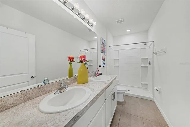a bathroom with a granite countertop sink a toilet and shower