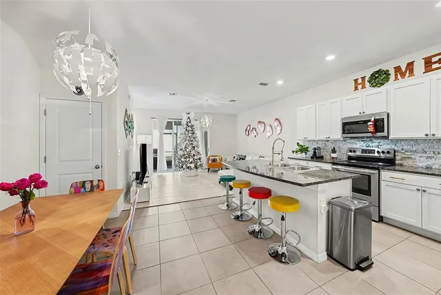 a very nice looking dining room with kitchen island furniture and a chandelier