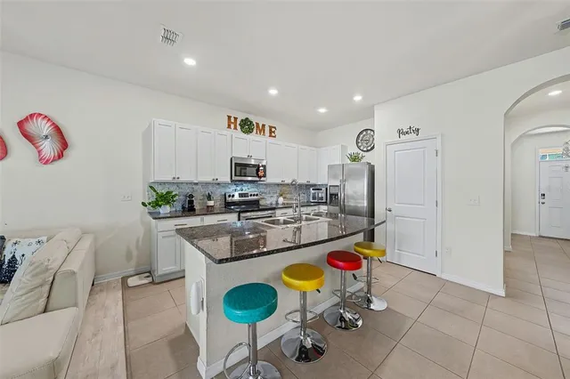 a kitchen with stainless steel appliances kitchen island granite countertop a refrigerator and stove