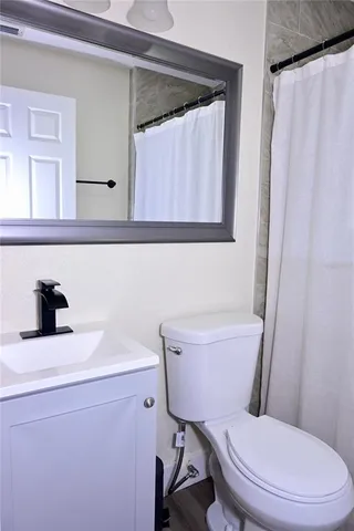 a bathroom with a sink a toilet and a mirror