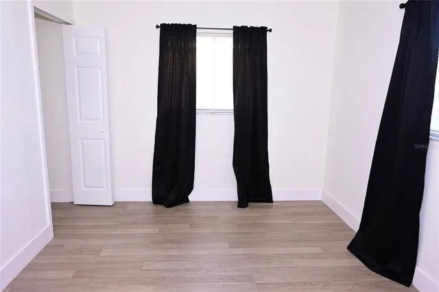 a view of an empty room with wooden floor