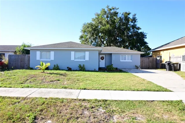 a view of a house with a yard and wooden fence