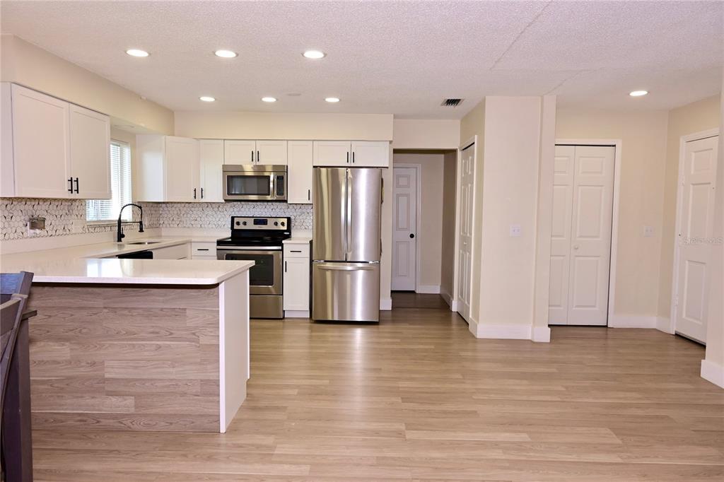 306 Fern Road Winter Haven, FL 33880 - Photo 5 of 20 a kitchen with stainless steel appliances granite countertop a refrigerator stove a sink and white cabinets