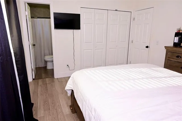 a bedroom with a bed and a flat tv screen