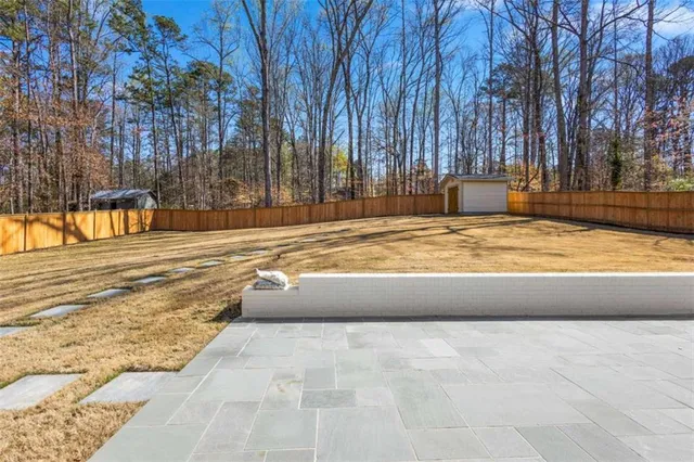 an empty room with wooden floor chandelier and windows