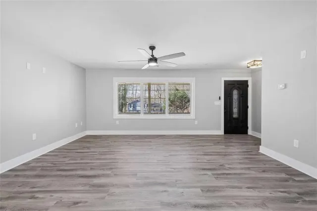 a view of a livingroom with wooden floor and a ceiling fan