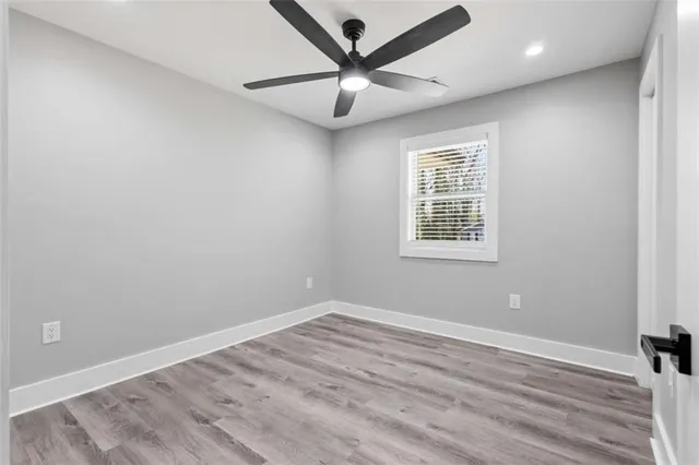 an empty room with closet and a ceiling fan