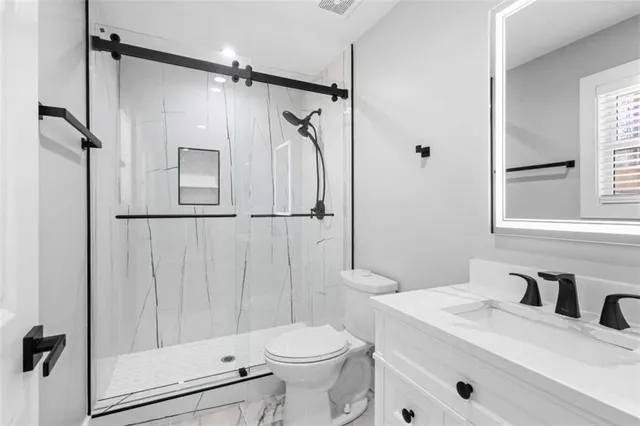 a bathroom with a sink toilet vanity and tub