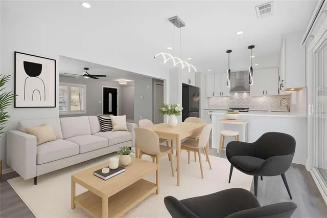 a view of a patio with couches table and chairs with wooden floor and fence
