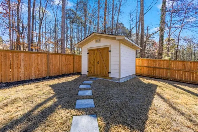 a view of backyard with wooden fence and large trees