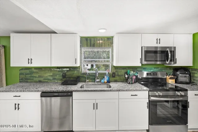 a kitchen with stainless steel appliances granite countertop a sink and a stove