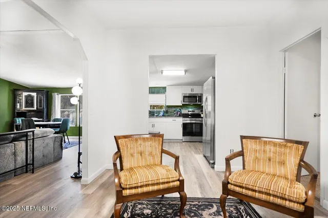 a living room with furniture and kitchen view