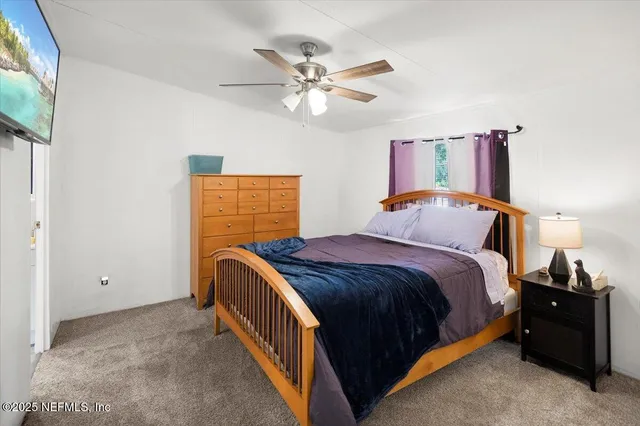 a bed room with a bed and a ceiling fan