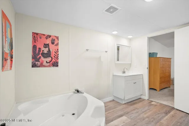 a bathroom with a bathtub sink and mirror