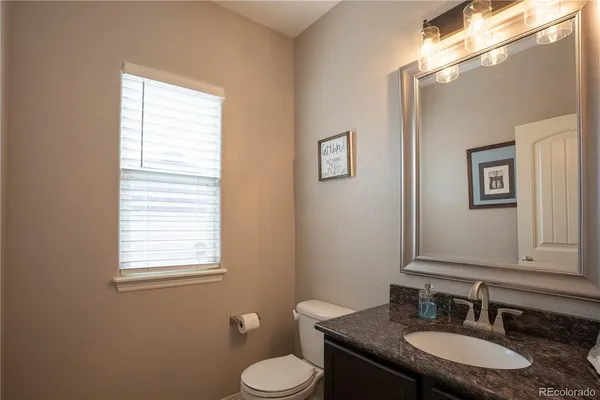 a bathroom with a granite countertop double vanity sink and a mirror