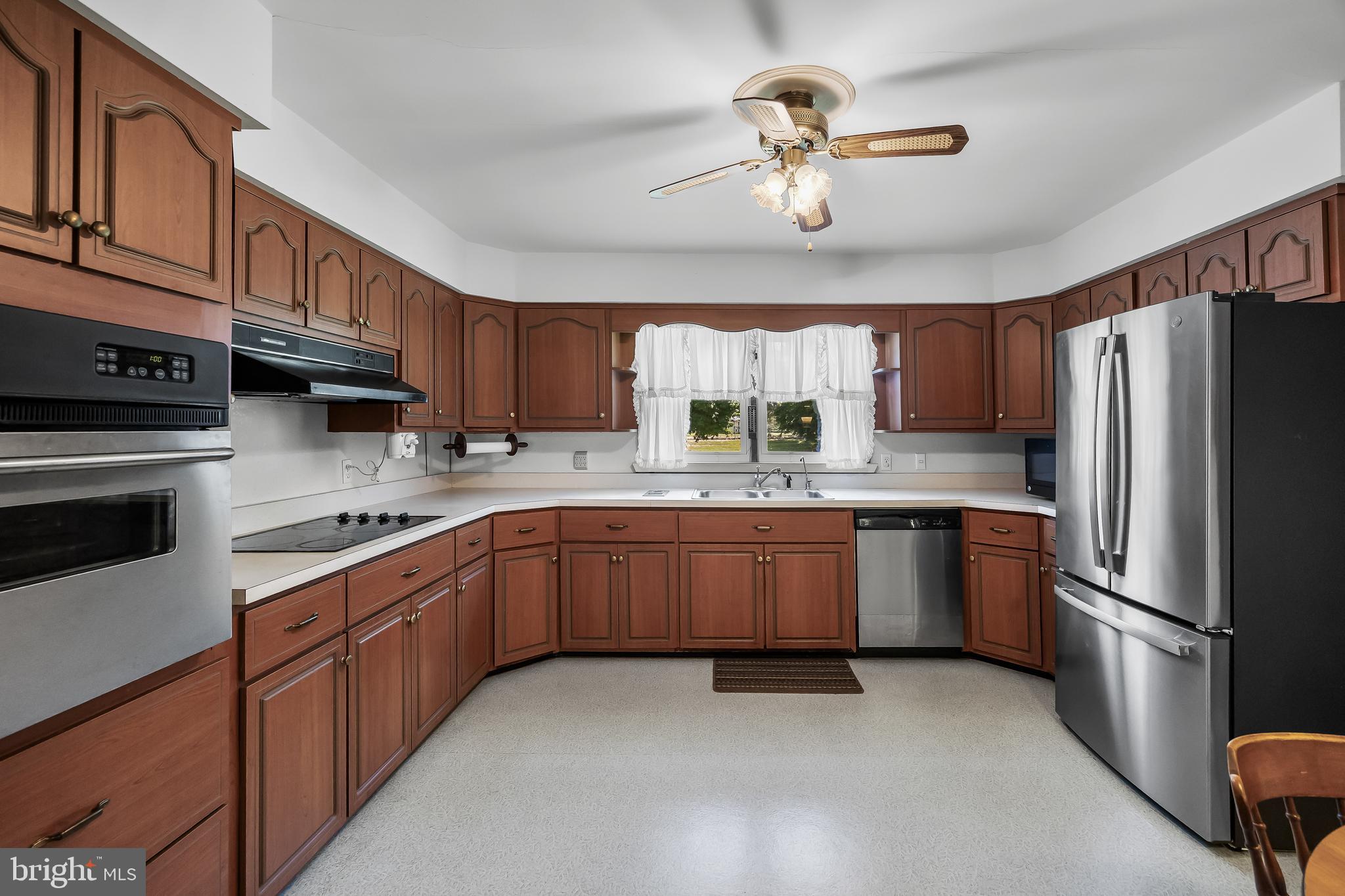 44 Supawna Road Pennsville, NJ 08070 - Photo 12 of 56 a kitchen with stainless steel appliances granite countertop a refrigerator a sink dishwasher a stove with wooden cabinets and floor