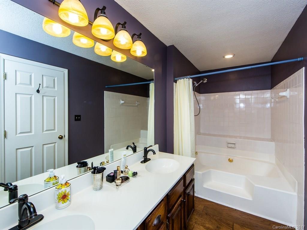5003 Sharon Road, Unit B Charlotte, NC 28210 - Photo 12 of 20 a bathroom with a sink a tub and a mirror