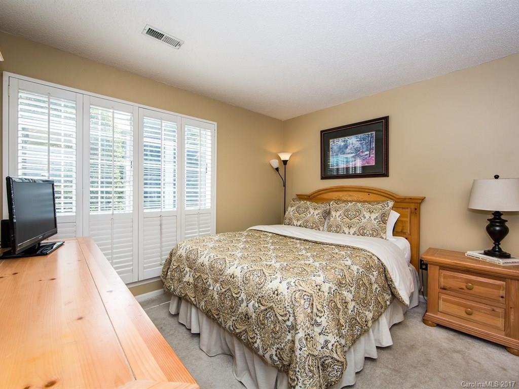 5003 Sharon Road, Unit B Charlotte, NC 28210 - Photo 13 of 20 a bedroom with a bed and a flat screen tv
