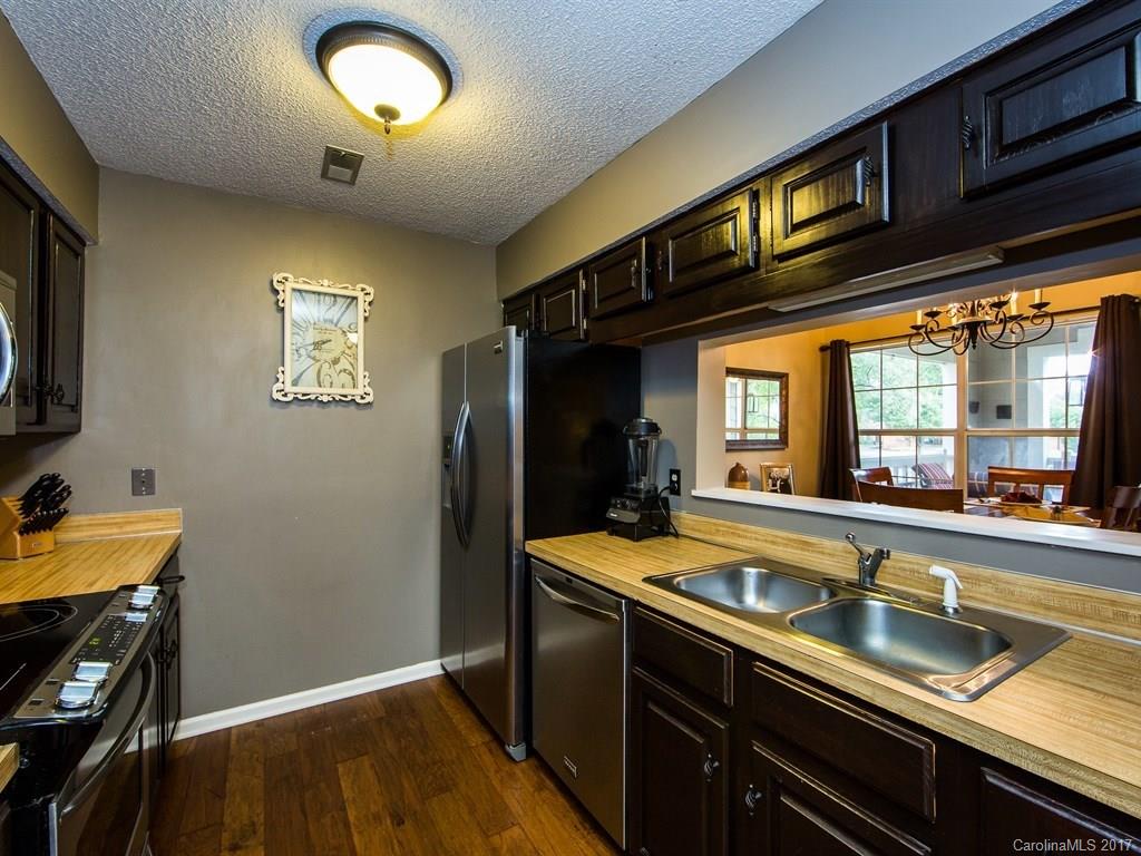 5003 Sharon Road, Unit B Charlotte, NC 28210 - Photo 7 of 20 a kitchen with stainless steel appliances granite countertop a sink a stove and a refrigerator