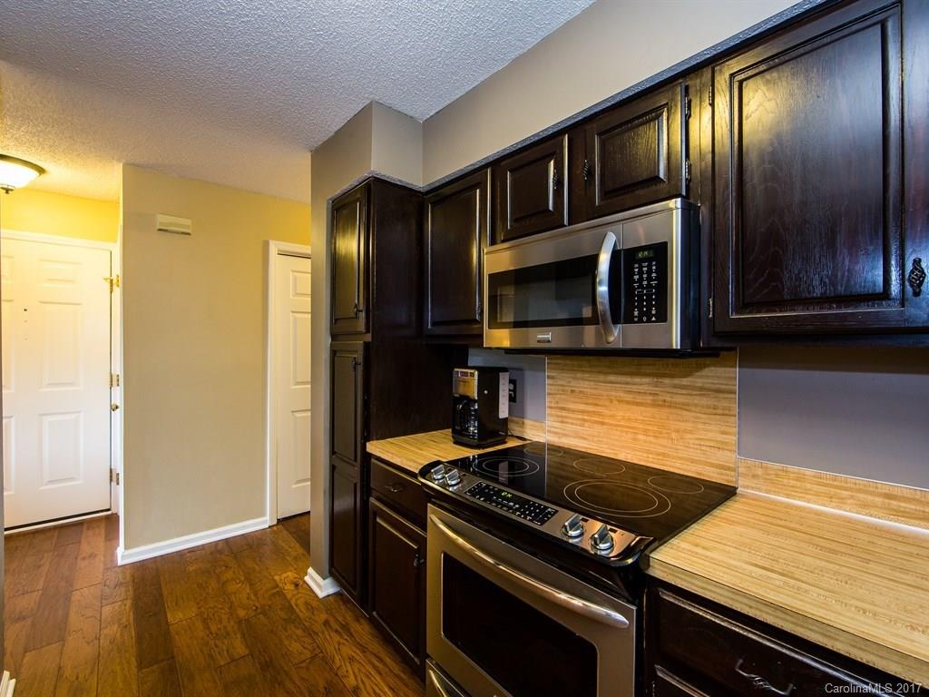 5003 Sharon Road, Unit B Charlotte, NC 28210 - Photo 9 of 20 a kitchen with granite countertop stainless steel appliances and wooden cabinets