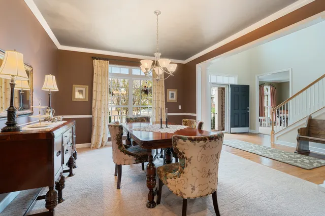 a kitchen with stainless steel appliances granite countertop a kitchen island hardwood floor sink stove dining table and chairs