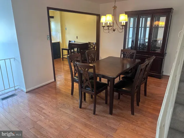 a large kitchen with sink a refrigerator and wooden floor