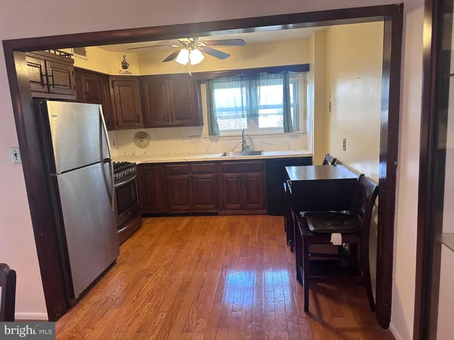 a kitchen with wooden floors and refrigerator